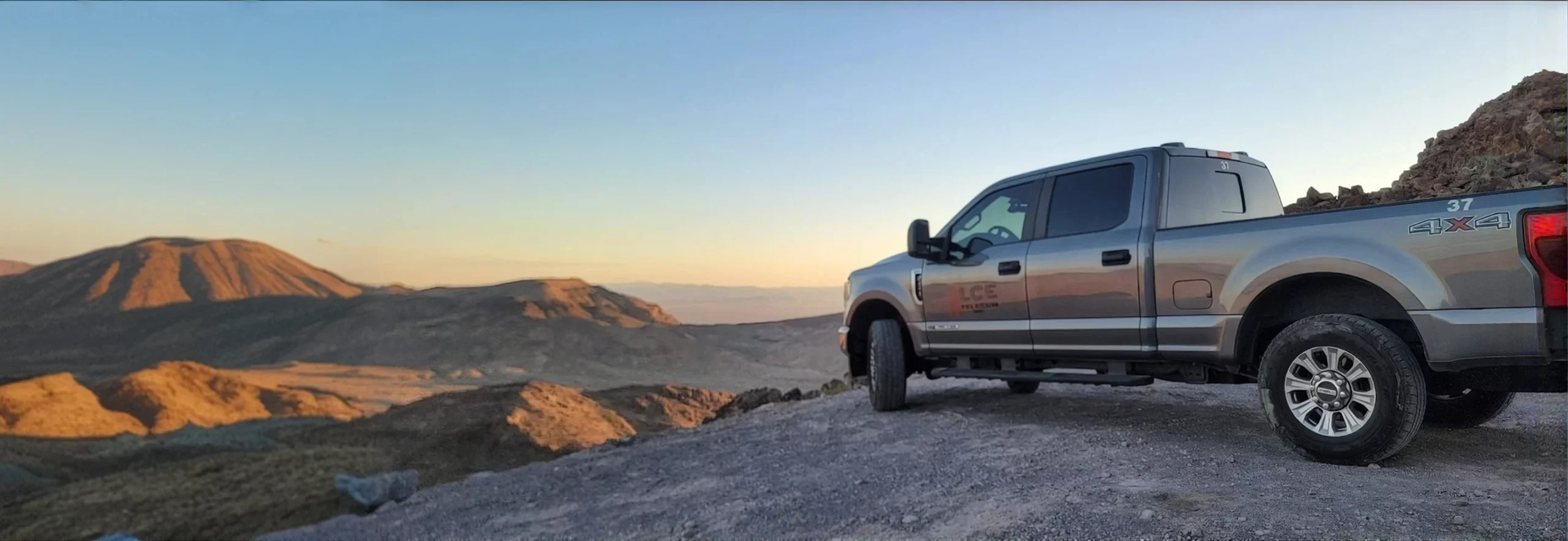 LCE Telecom field service truck overlooking a remote mountain landscape while supporting telecommunications infrastructure.